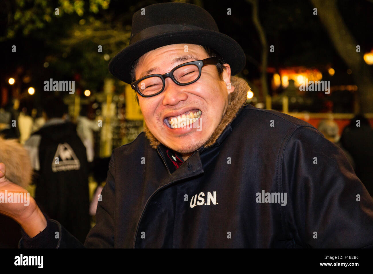 New Year's eve, Nishinomiya shrine, midnight, man facing viewer,  pulling funny face by laughing with glasses on and bearing teeth. Head and shoulders. Stock Photo