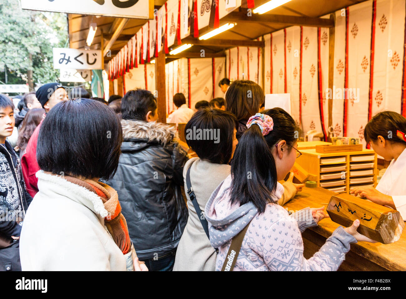 Japan, Nishinomiya shrine, New year Day, Shogatsu. Woman buying omikuji ...