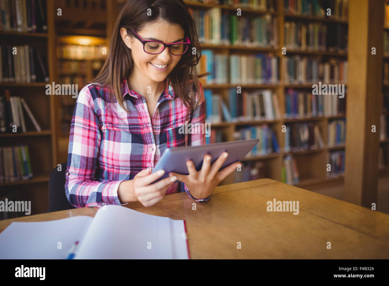 Happy female student using digital tablet Stock Photo