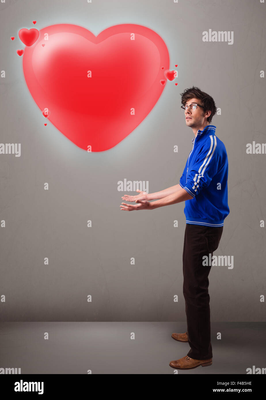 Young man holding lovely 3d red heart Stock Photo - Alamy