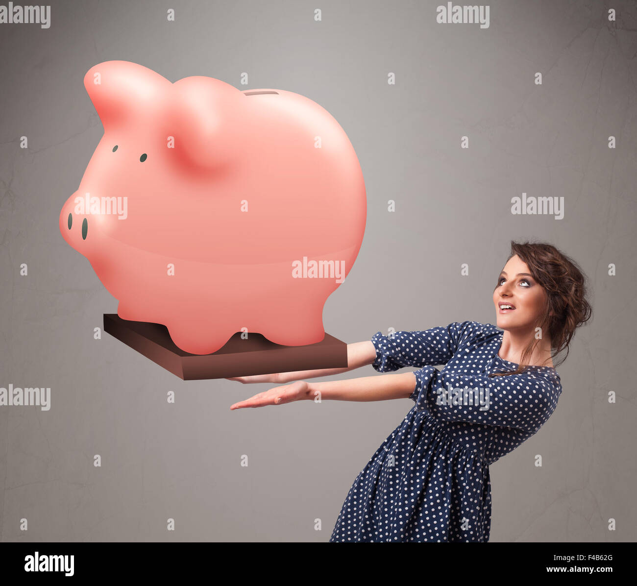 Young girl holding a huge savings piggy bank Stock Photo - Alamy