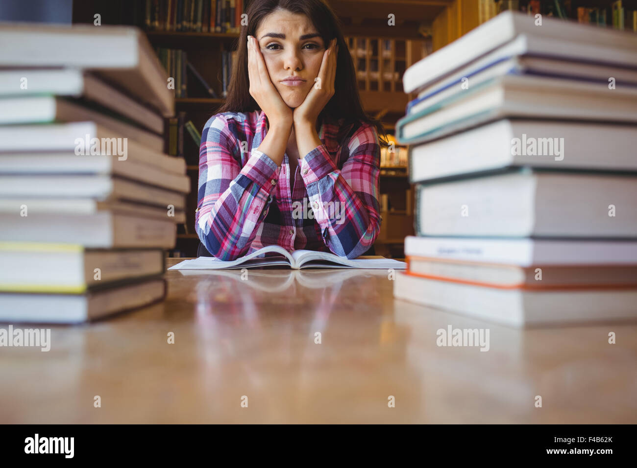 Frustrated female student at desk Stock Photo