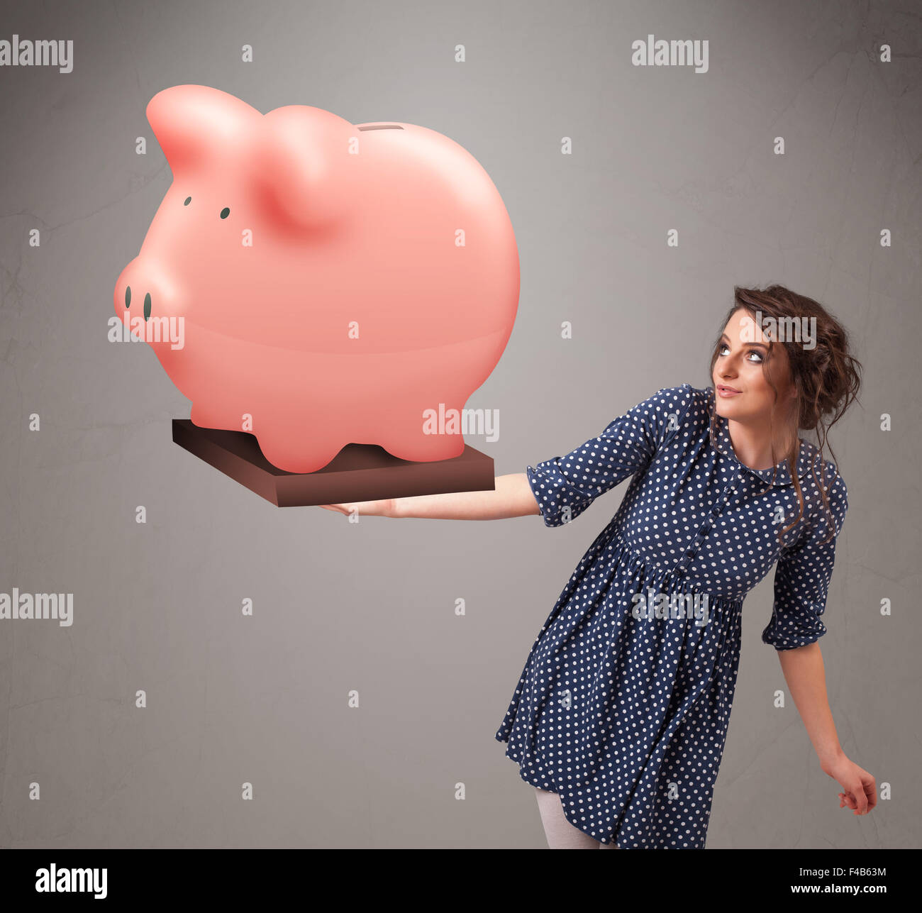 Young girl holding a huge savings piggy bank Stock Photo - Alamy