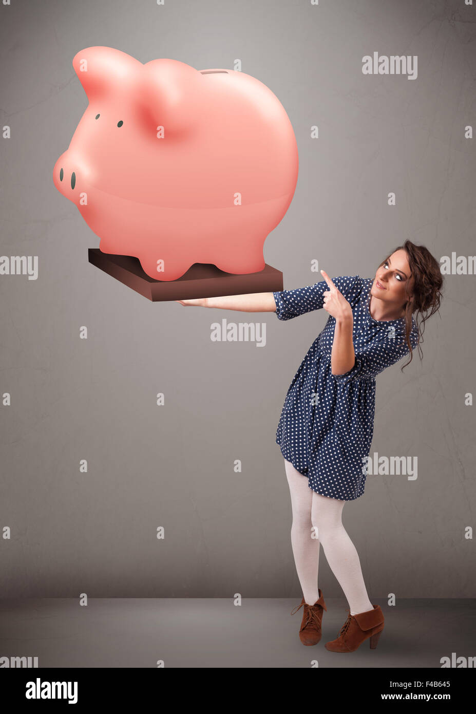 Young girl holding a huge savings piggy bank Stock Photo - Alamy