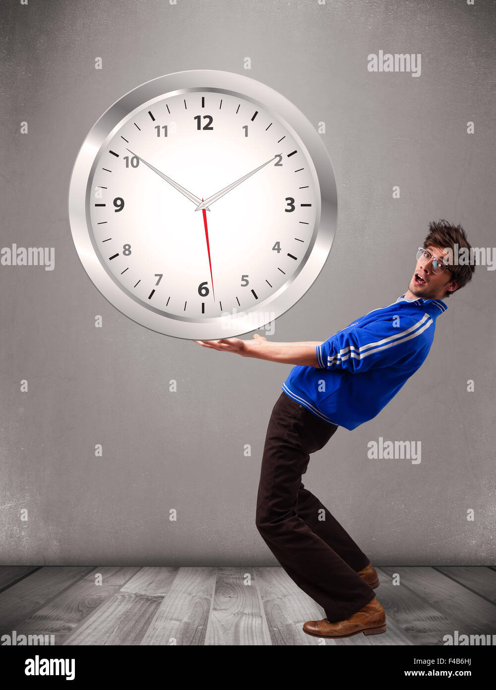 Attractive boy holding a huge clock Stock Photo - Alamy