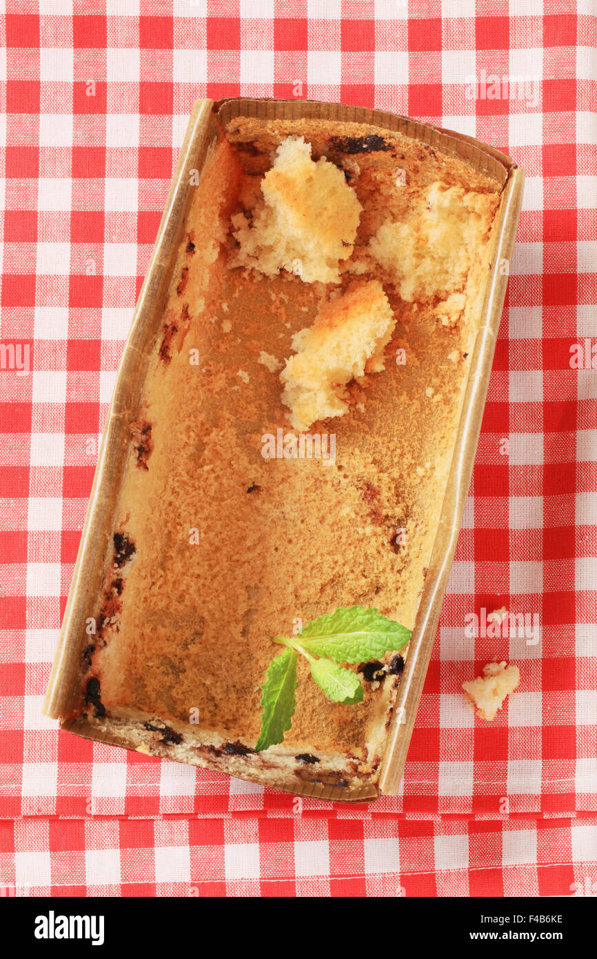 paper loaf pan with bits of sponge cake Stock Photo Alamy