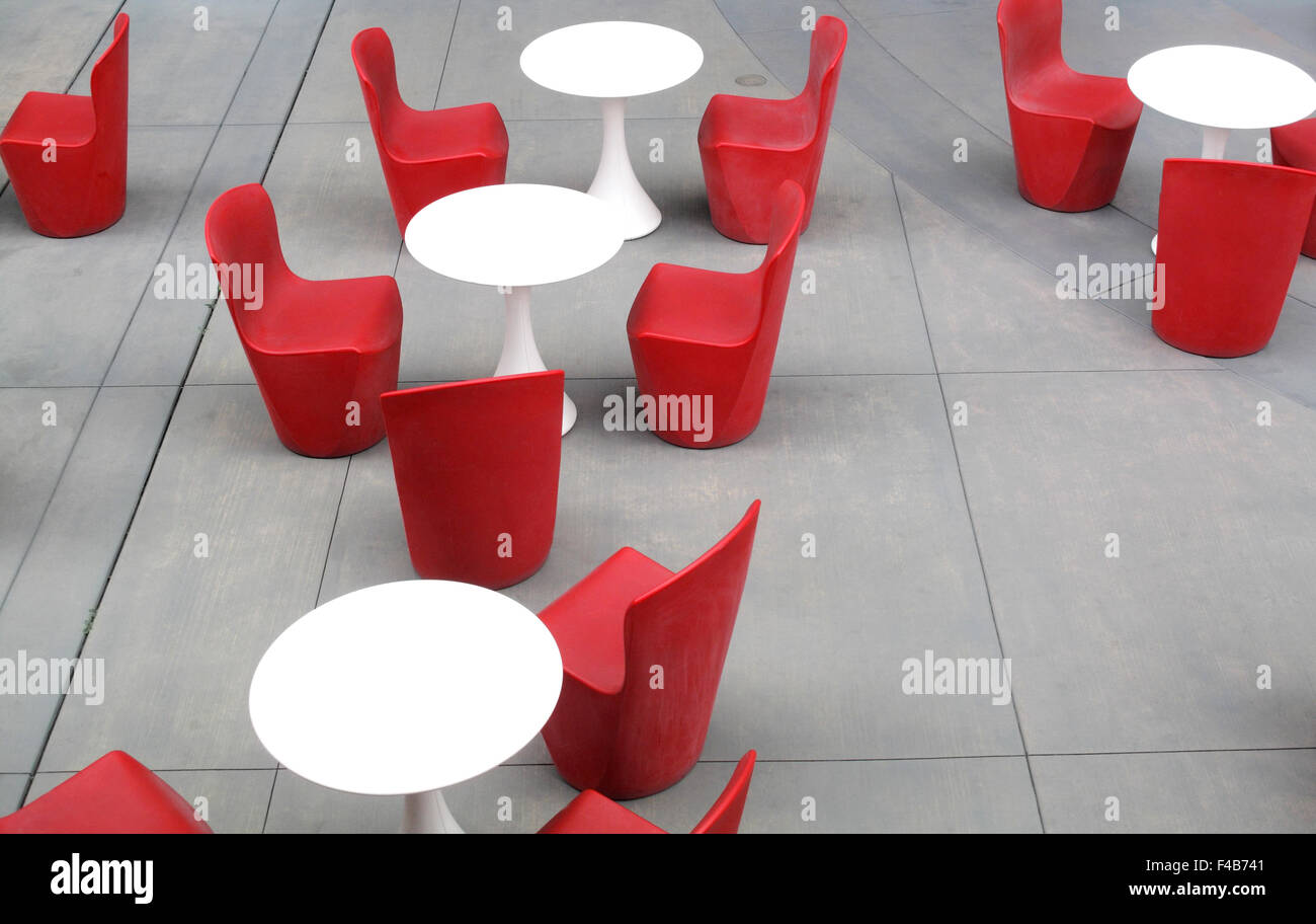 Plastic Red Chairs And White Tables On Concrete Patio In San Stock
