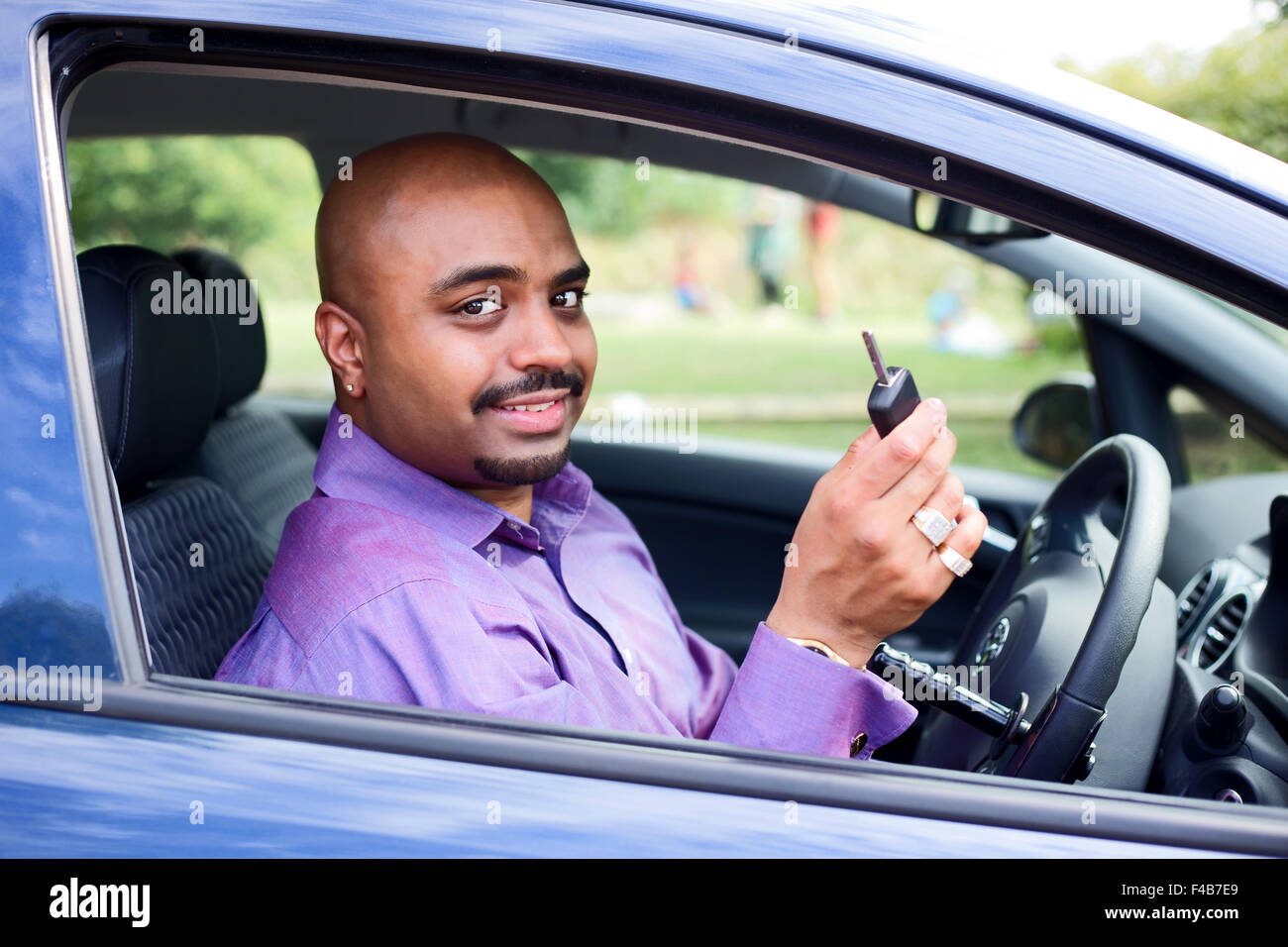 Driver with a steering wheel spinner showing his car key Stock Photo