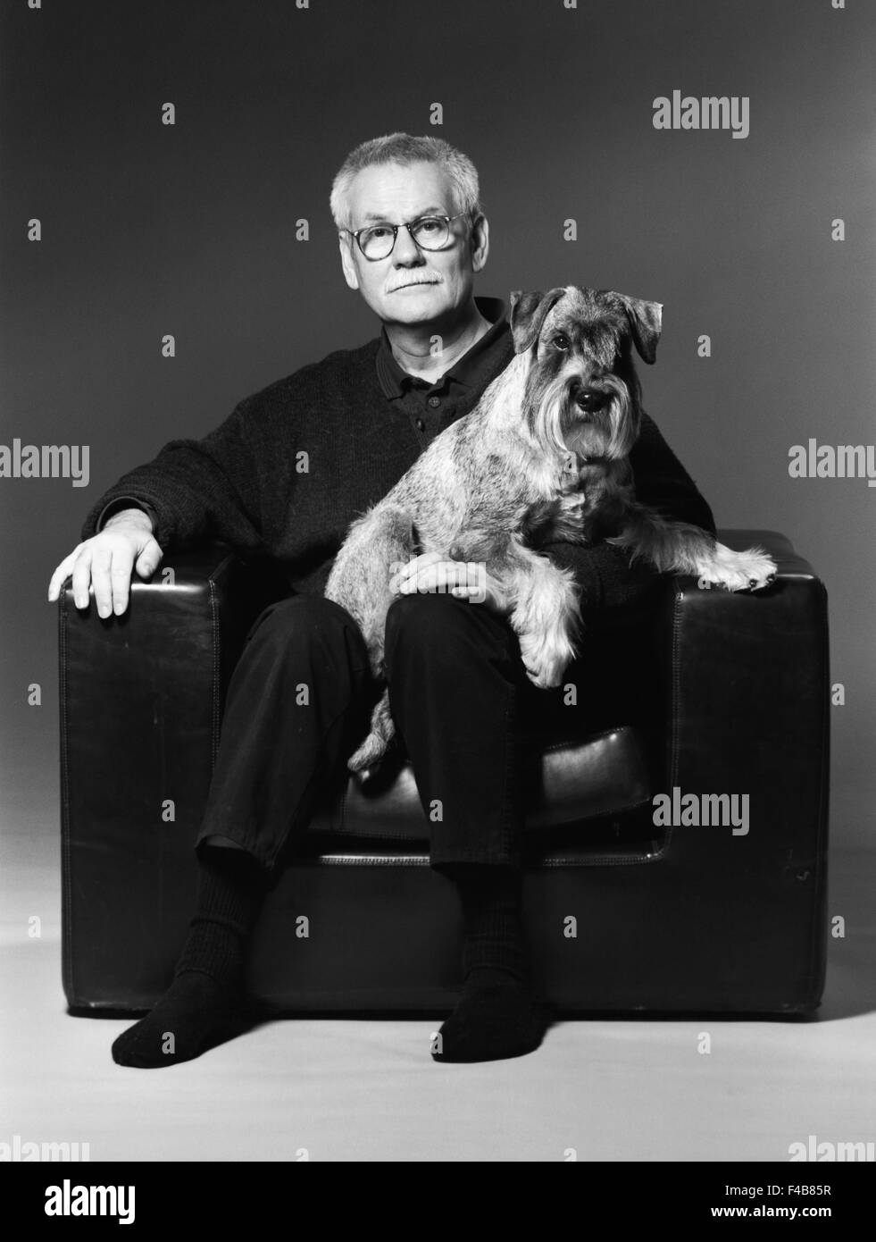 45-49 years adults only armchair black and white dog domestic animals emotional series expression friends glasses indoors man Stock Photo
