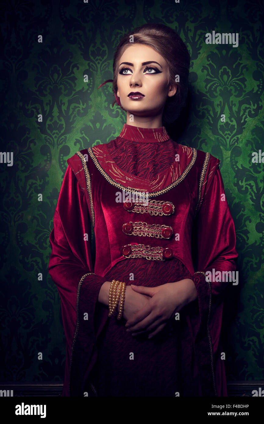 Aristocratic woman in vintage clothes on rococ period pattern. Rich