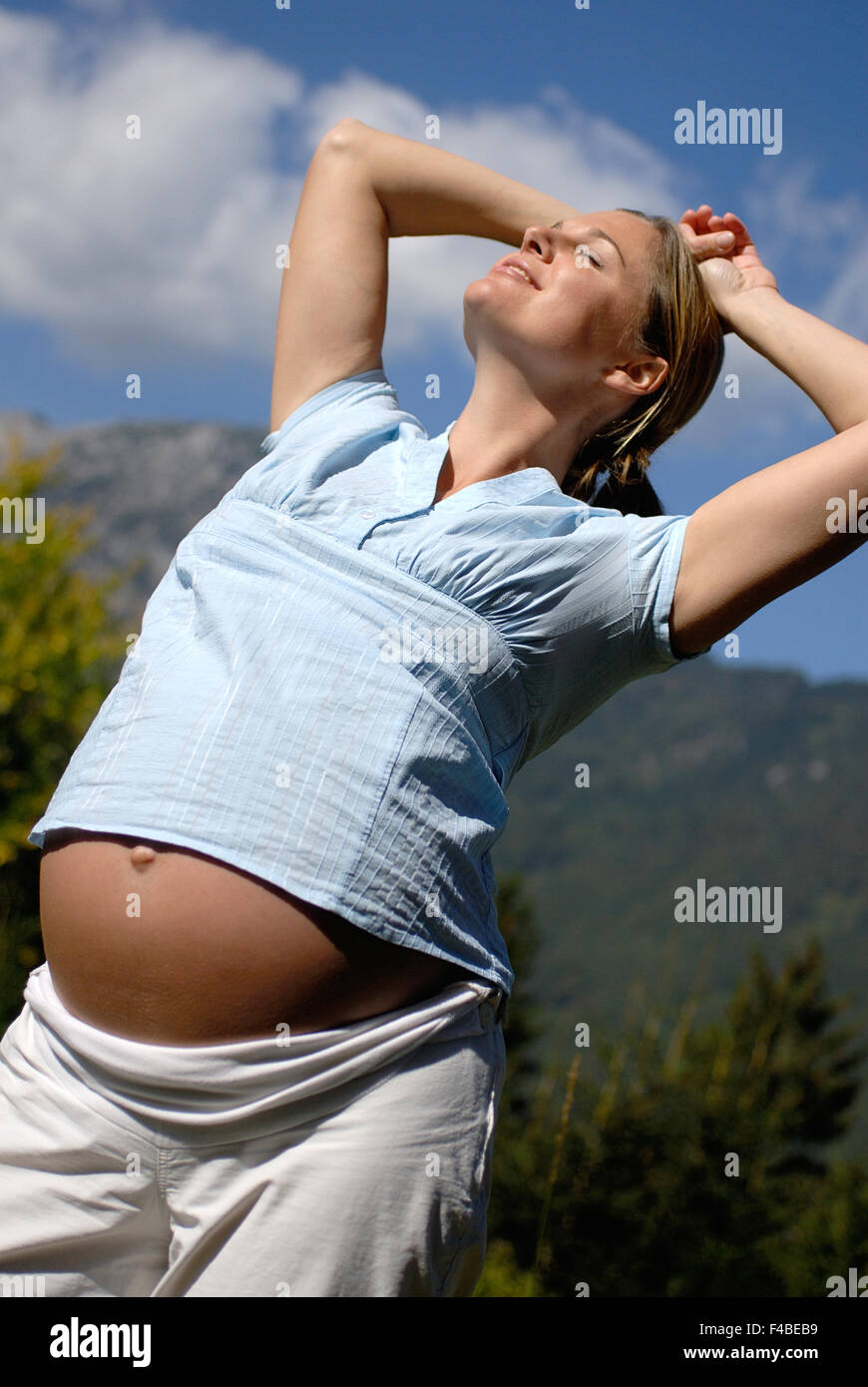 pregnant woman standing in the sun Stock Photo