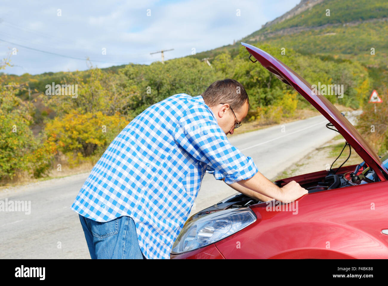 Adult man is standing near his broken car Stock Photo