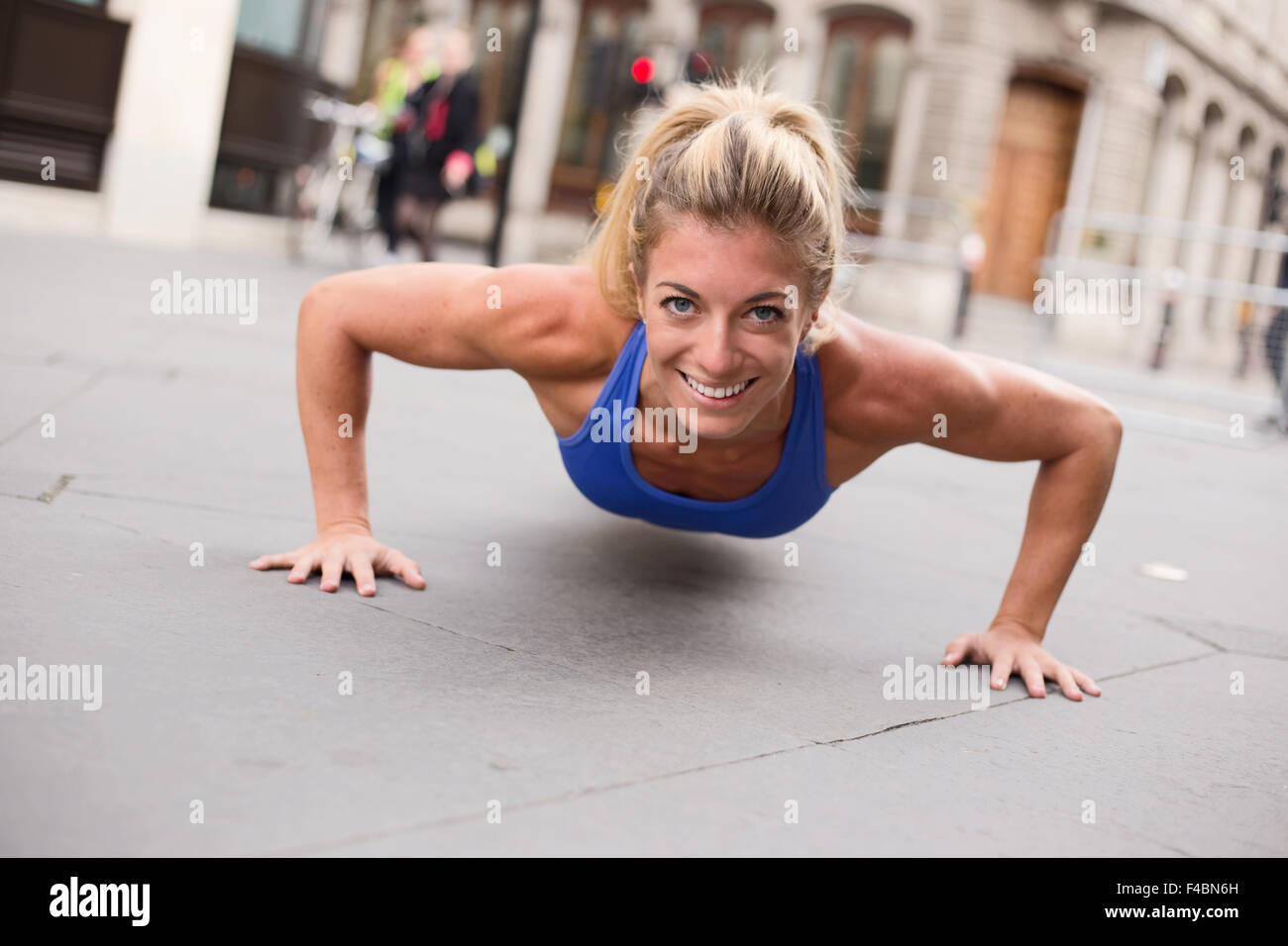 young woman exercising doing push ups Stock Photo