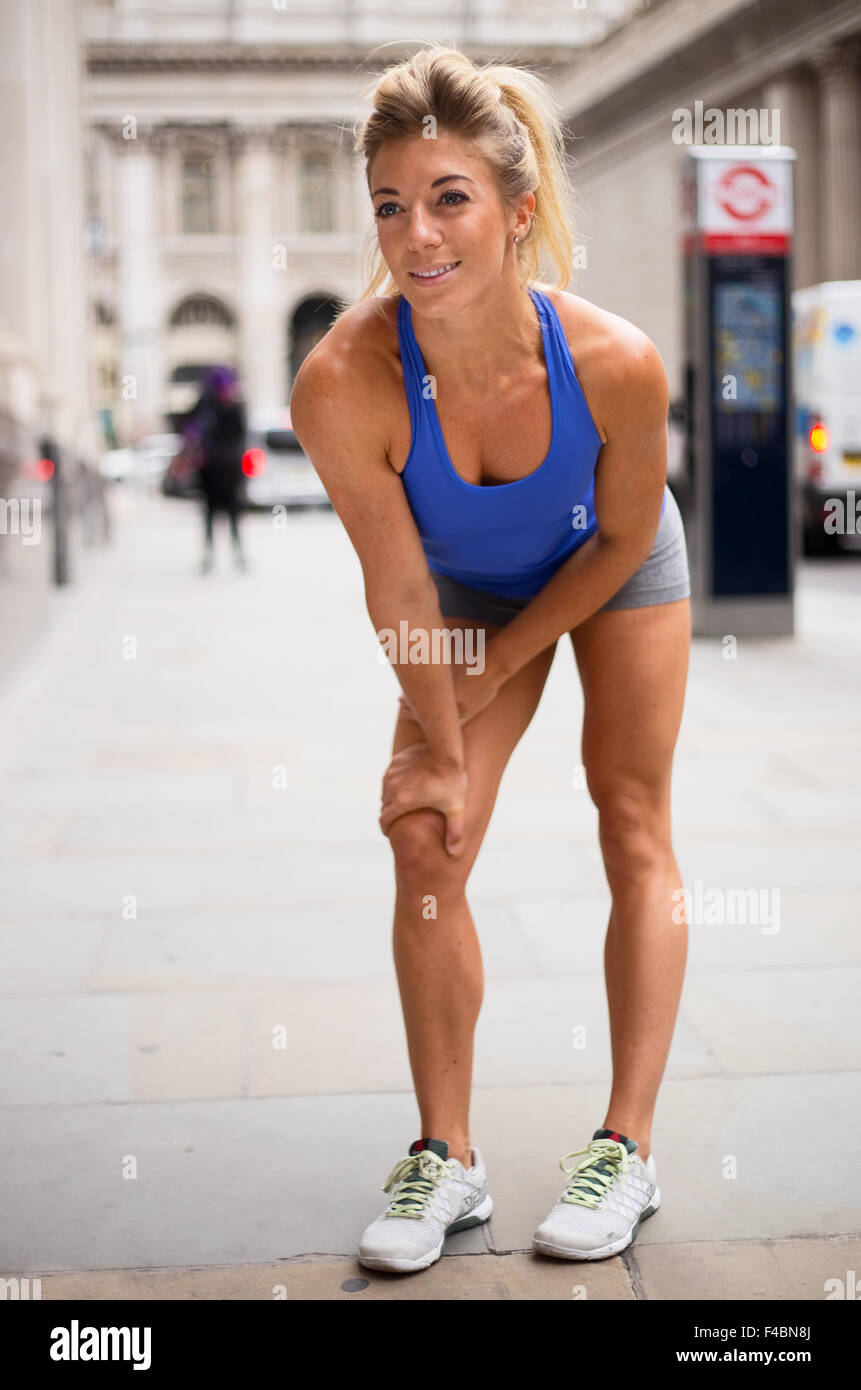 runner catching her breath in the city Stock Photo