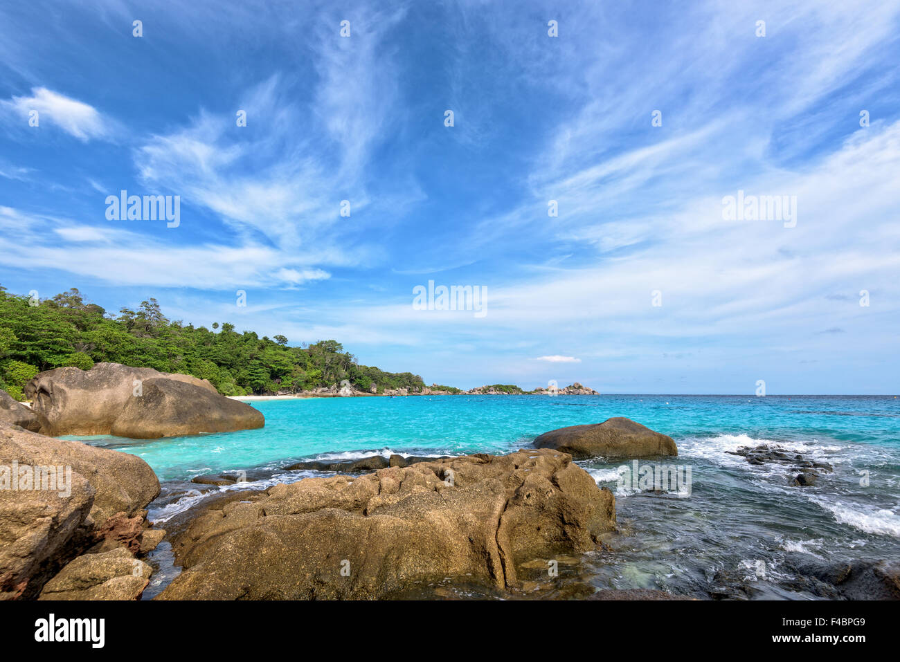 Beautiful landscape of blue sky sea and white waves on beach near the rocks during summer at Koh Miang island in Mu Ko Similan Stock Photo