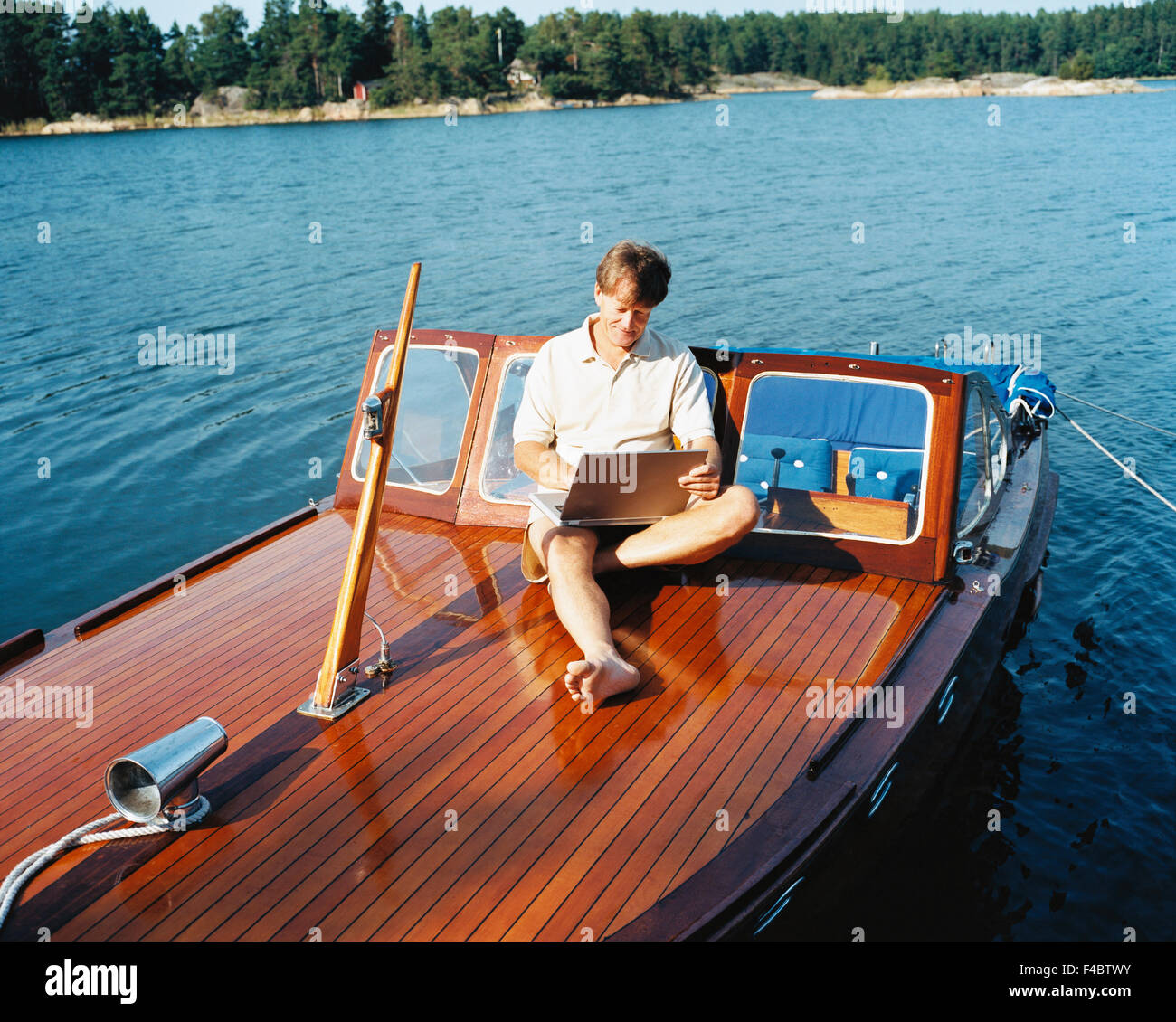 45-49 years activity adults only archipelago boat casual clothing color image computer connected horizontal Internet laptop Stock Photo