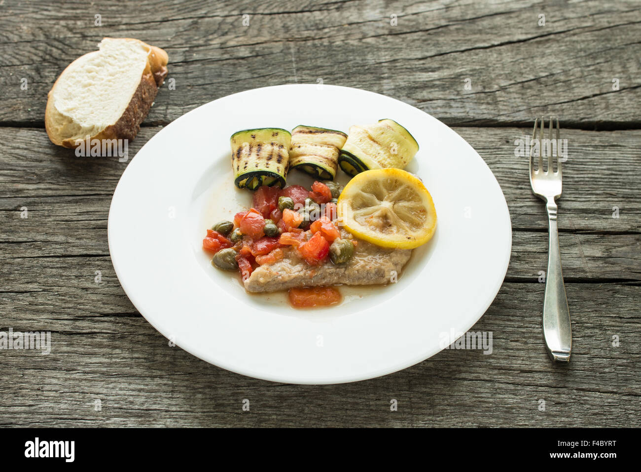 Veal cutlet with lemon sauce, tomatoes, capers and courgettes Stock
