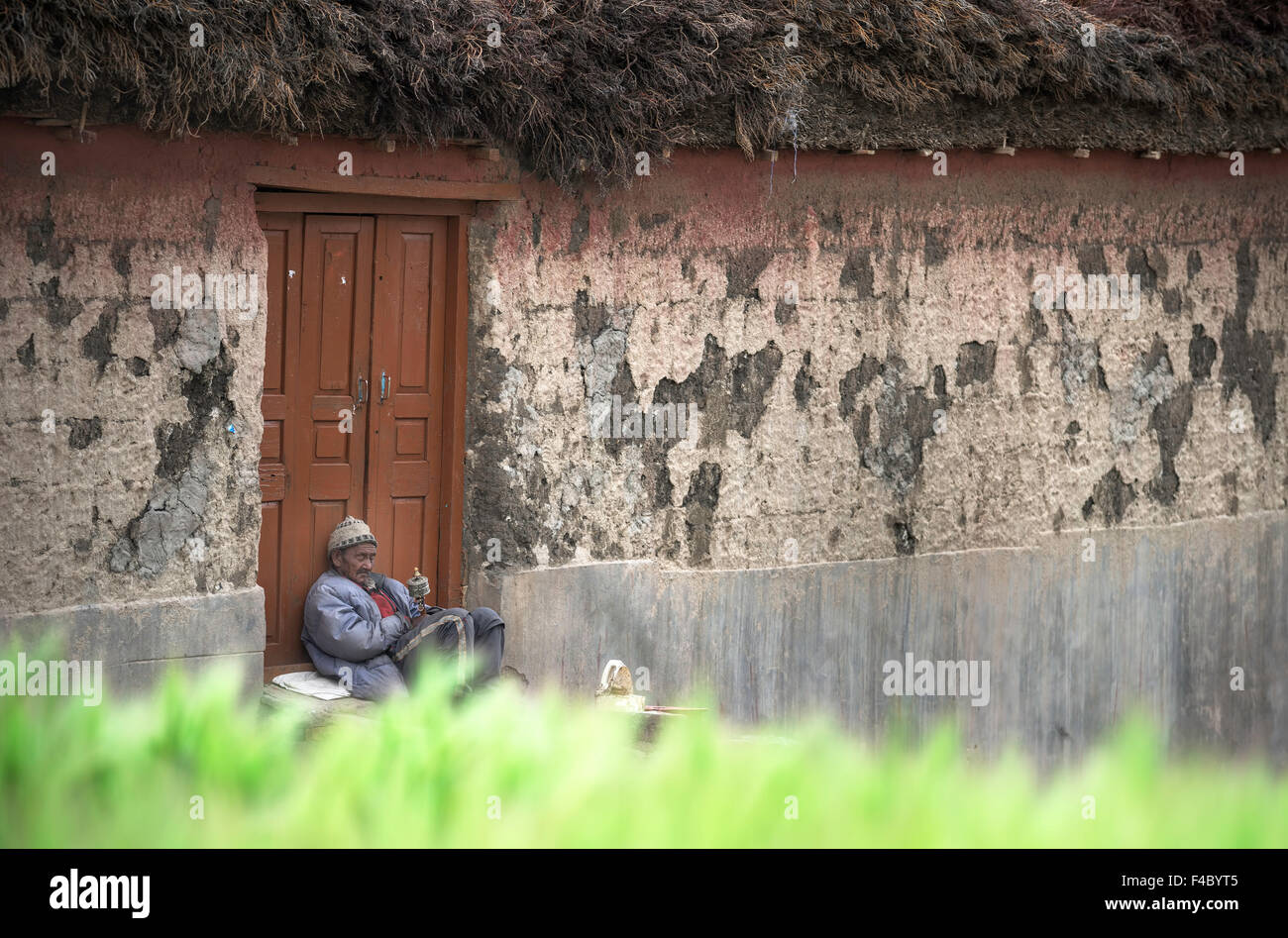 Old man busy with rosary and chanting Stock Photo