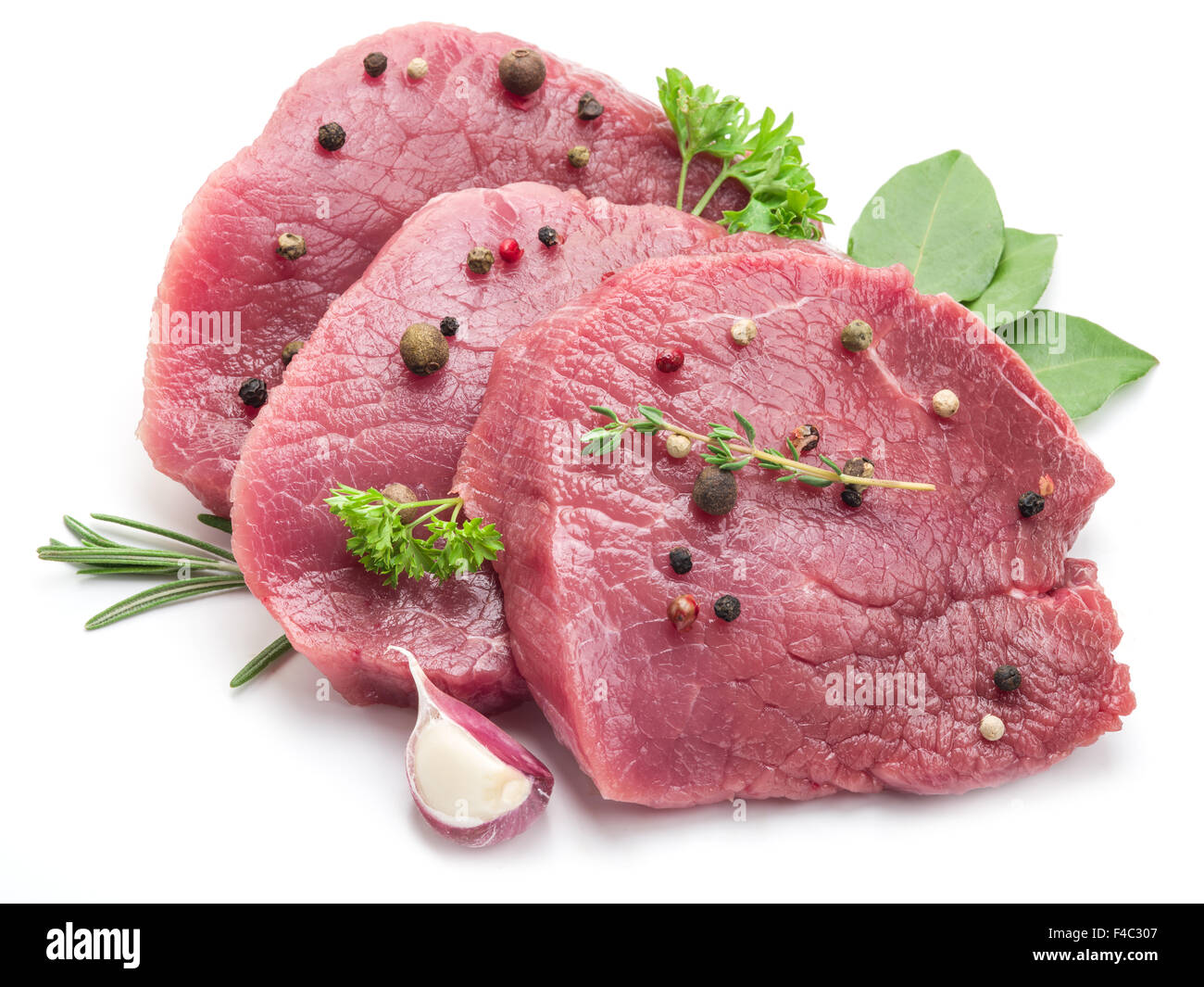 Raw beef steaks with spices on a white background. Stock Photo