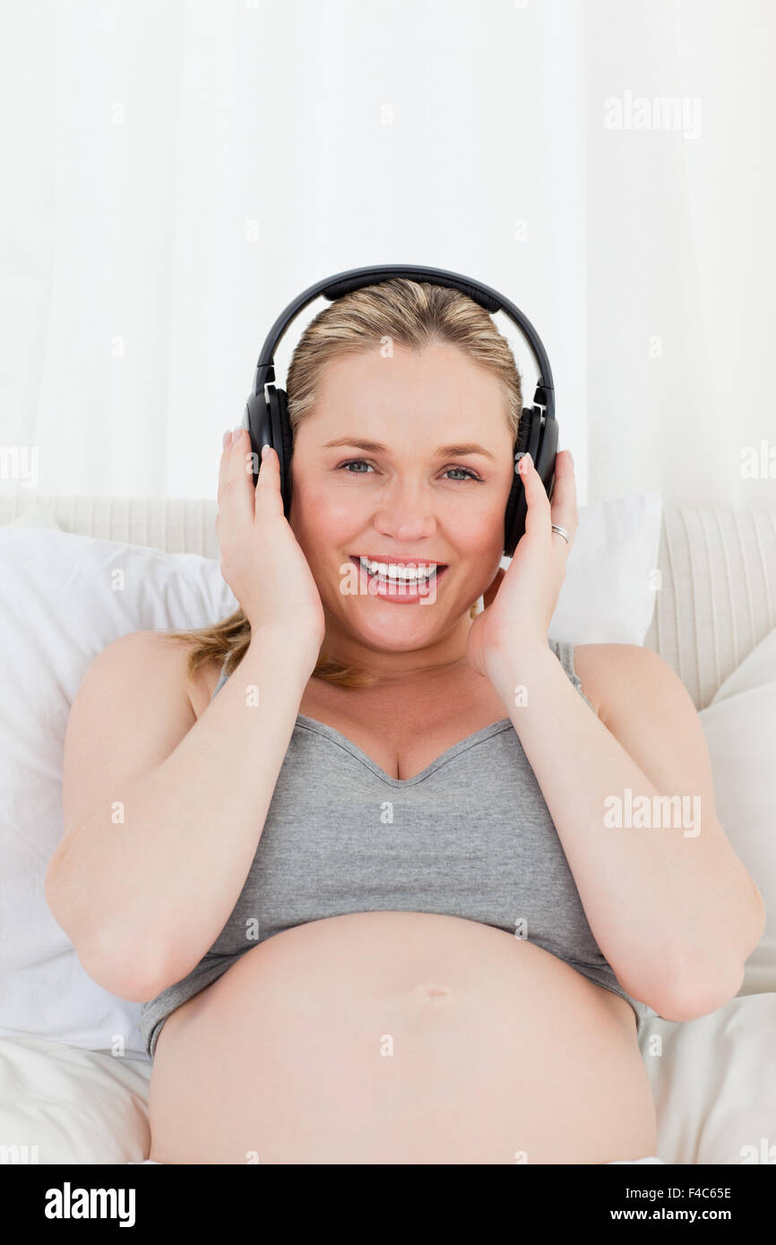 Lovely pregnant woman listening to music on her bed Stock Photo - Alamy