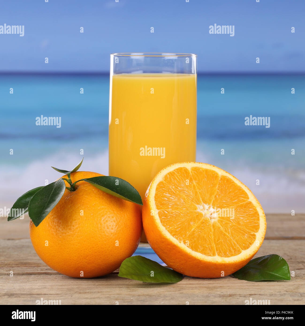 Orangensaft Getränk und Orangen am Strand und Meer Stock Photo