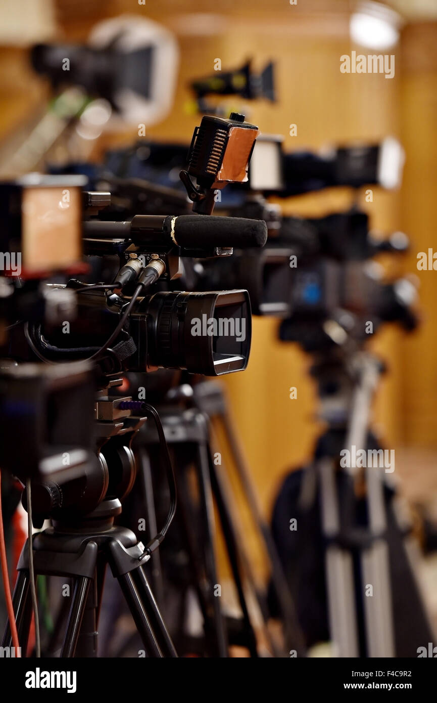 Several video cameras on tripods at a press conference Stock Photo