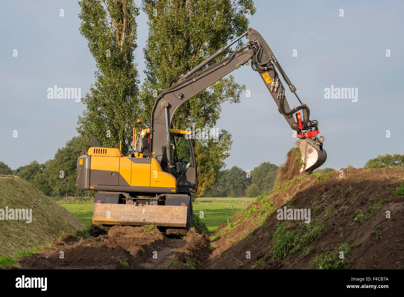 Agriculture shredded corn silage with an excavator in the Netherlands Stock Photo