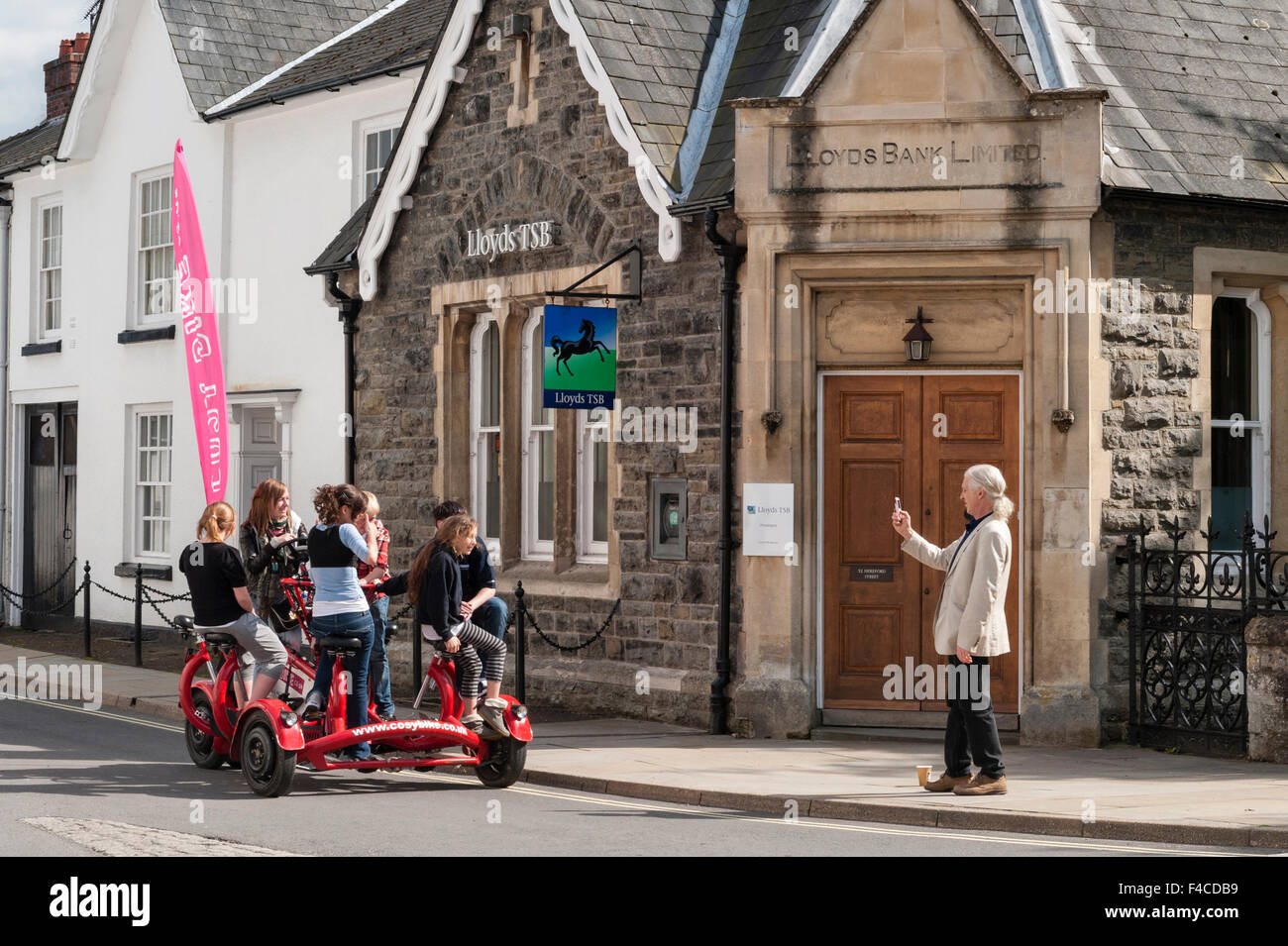 Presteigne, Powys, UK. A Cosybike, a seven seater 'conference bike' being ridden through the town Stock Photo
