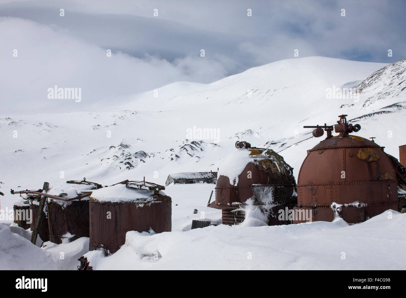 Antarctica, South Shetland Islands, Rusted boilers in late winter snow at abandoned whaling station at Whalers Cove on Deception Island. Stock Photo