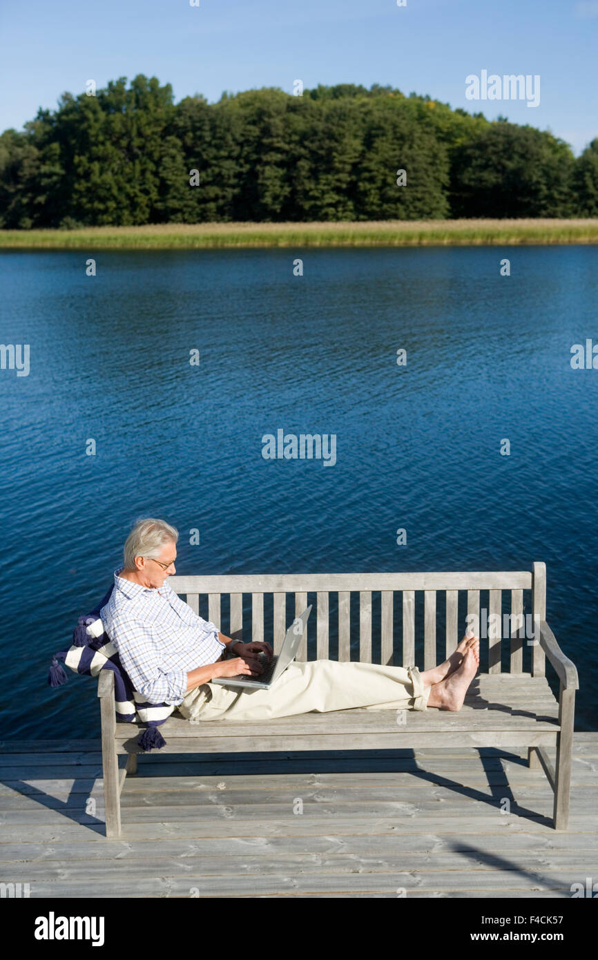A man on a bench with a laptop. Stock Photo