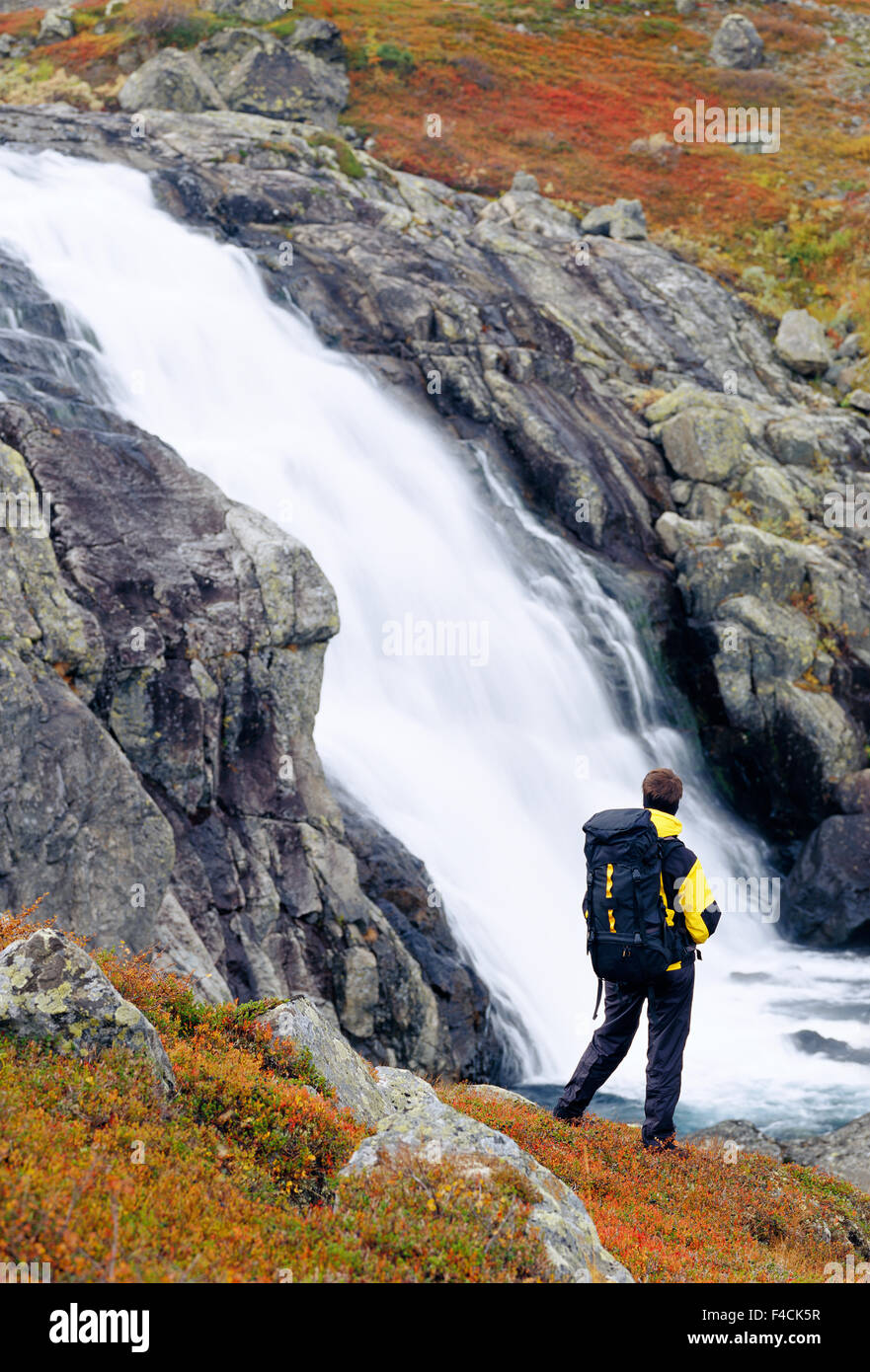 A person standing by a waterfall Stock Photo - Alamy