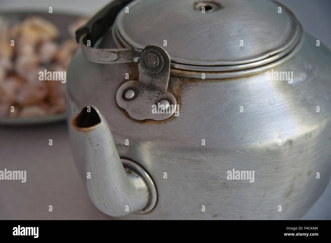 China, Xinjiang, Manas. A well-used aluminum tea pot sits on the table at Muslim restaurant. Stock Photo