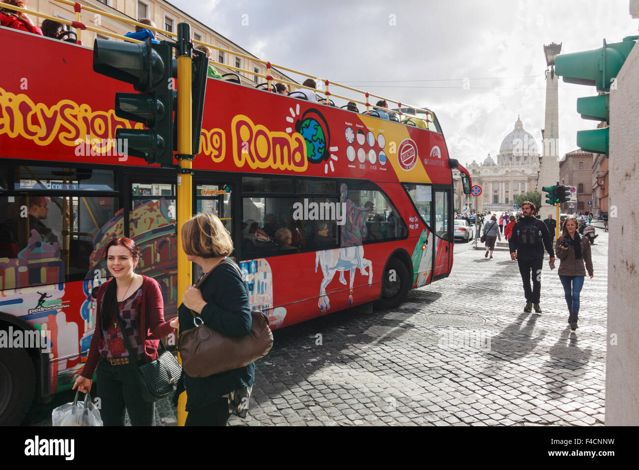 Two women next to a sightseeing bus at Vatican city, Rome, Italy Stock Photo