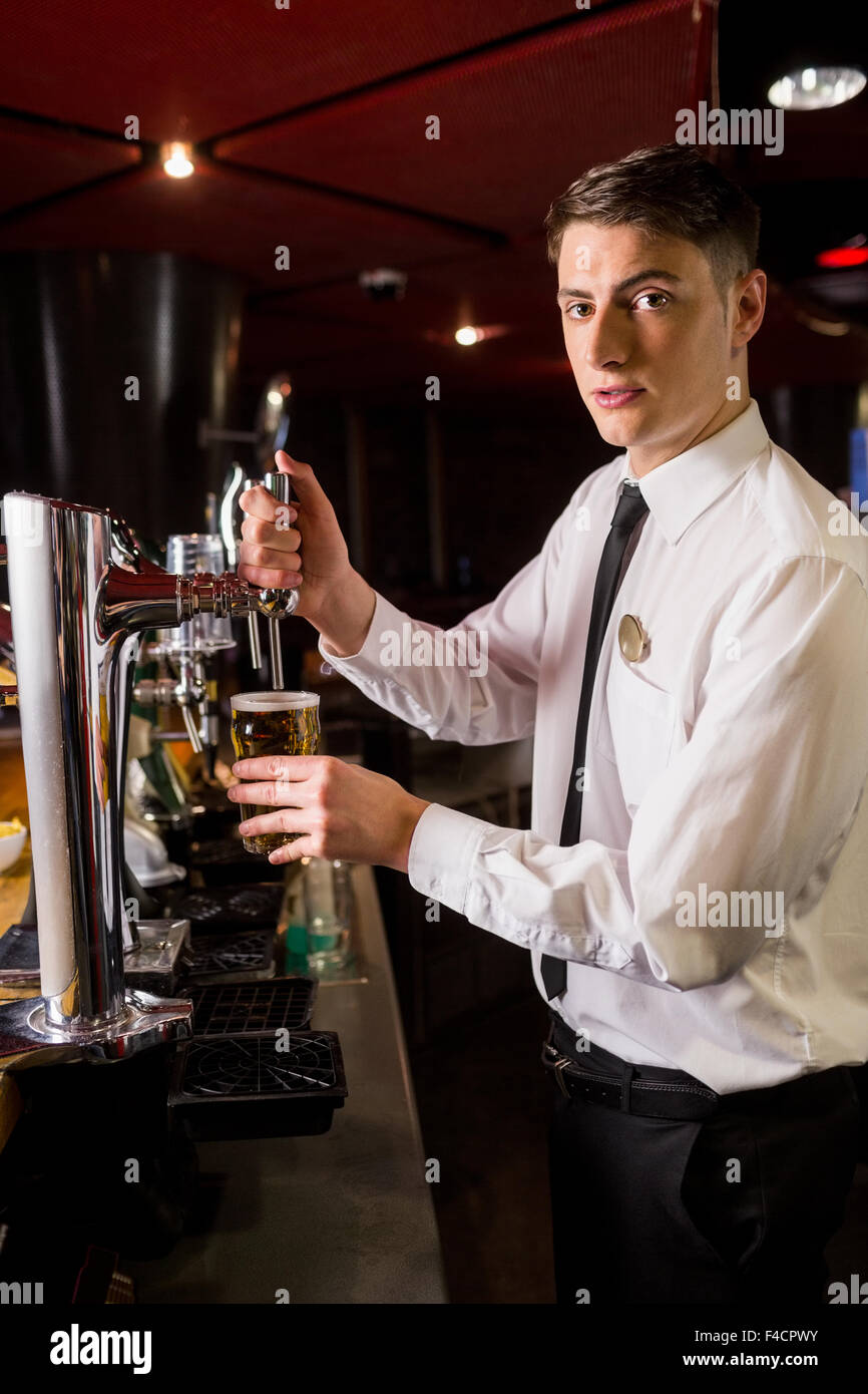 Well dressed bartender serving beer Stock Photo Alamy