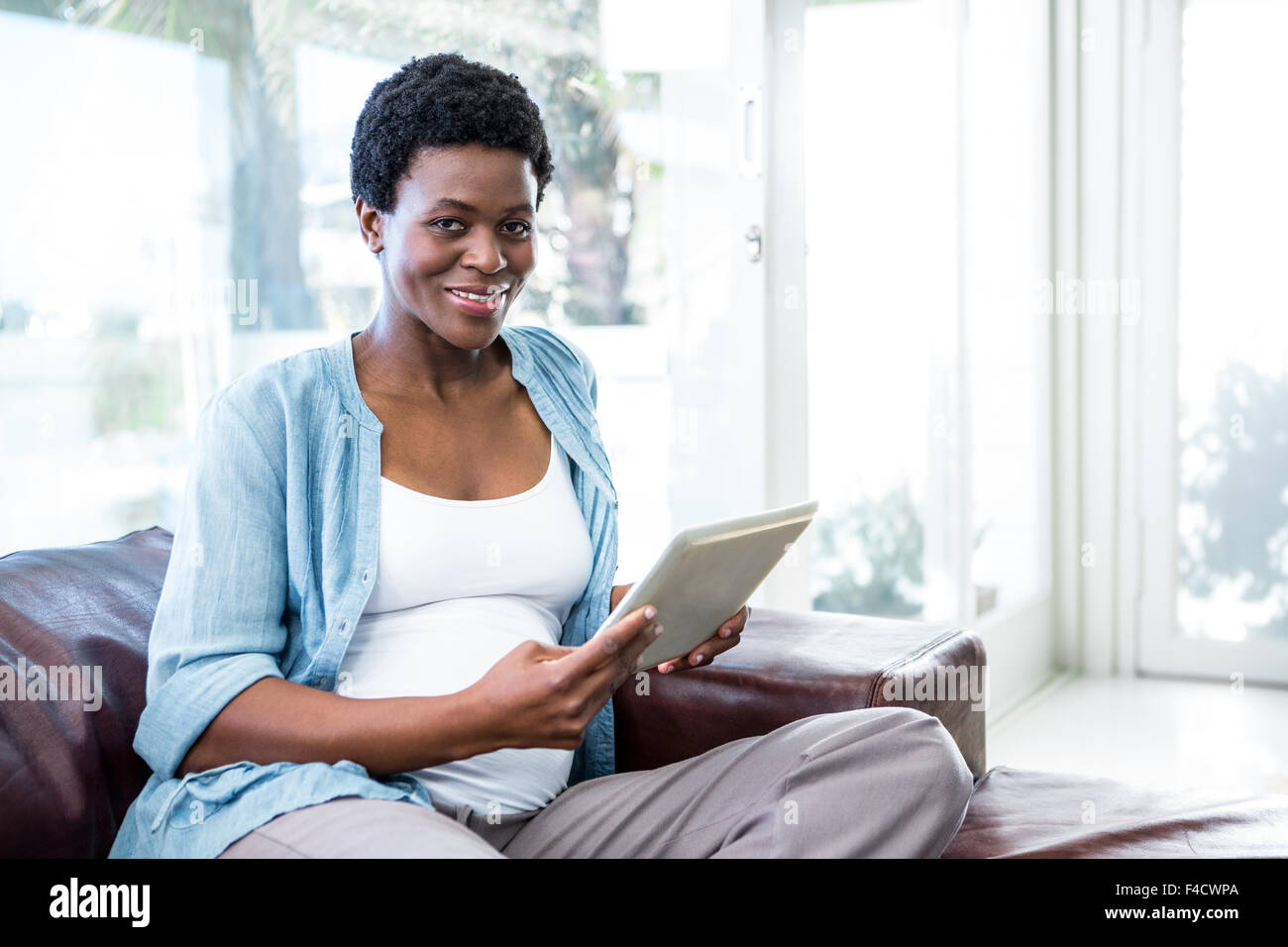 Happy woman using her tablet pc Stock Photo