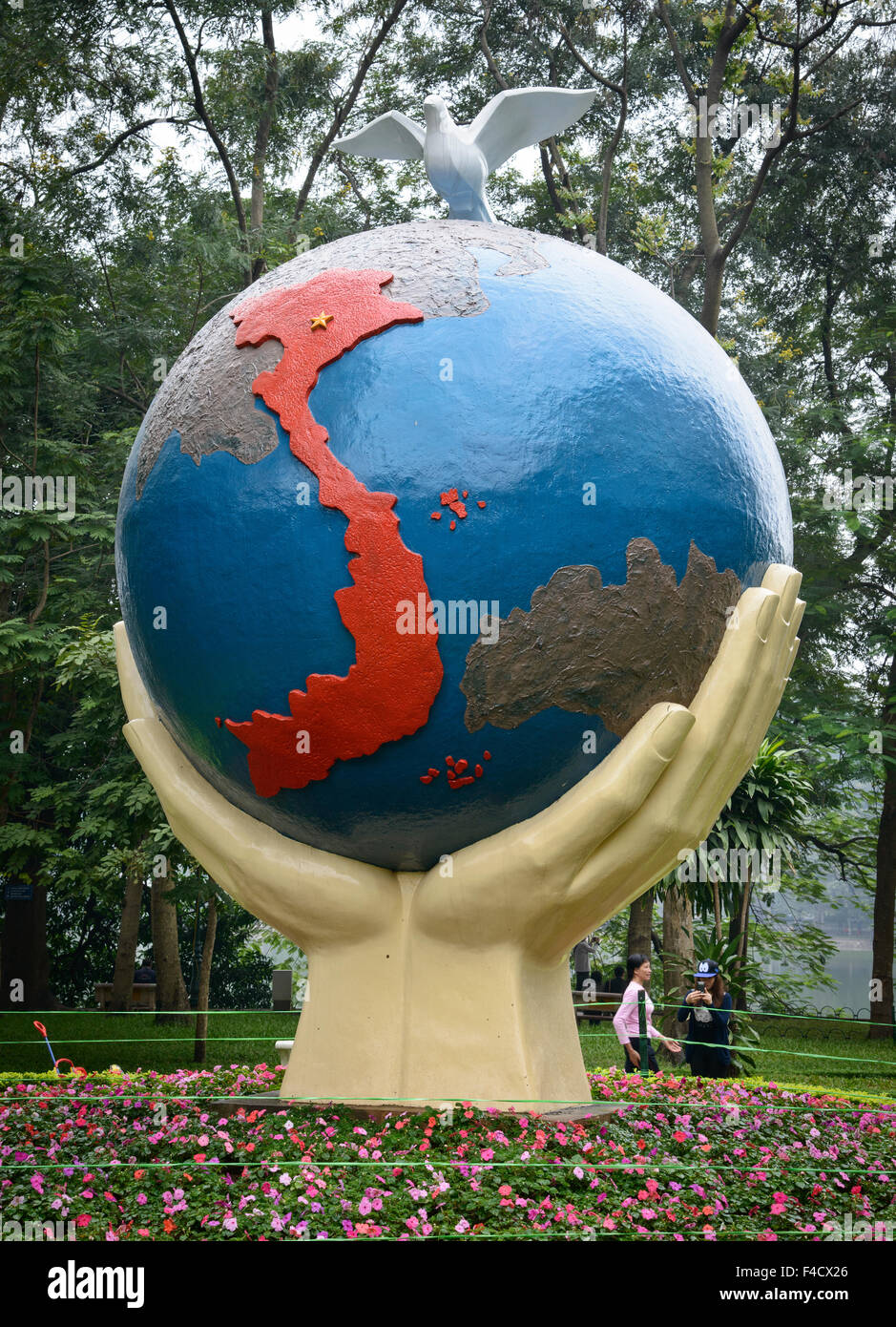 Vietnam, Hanoi. Sculpture of hands holding giant globe, with dove