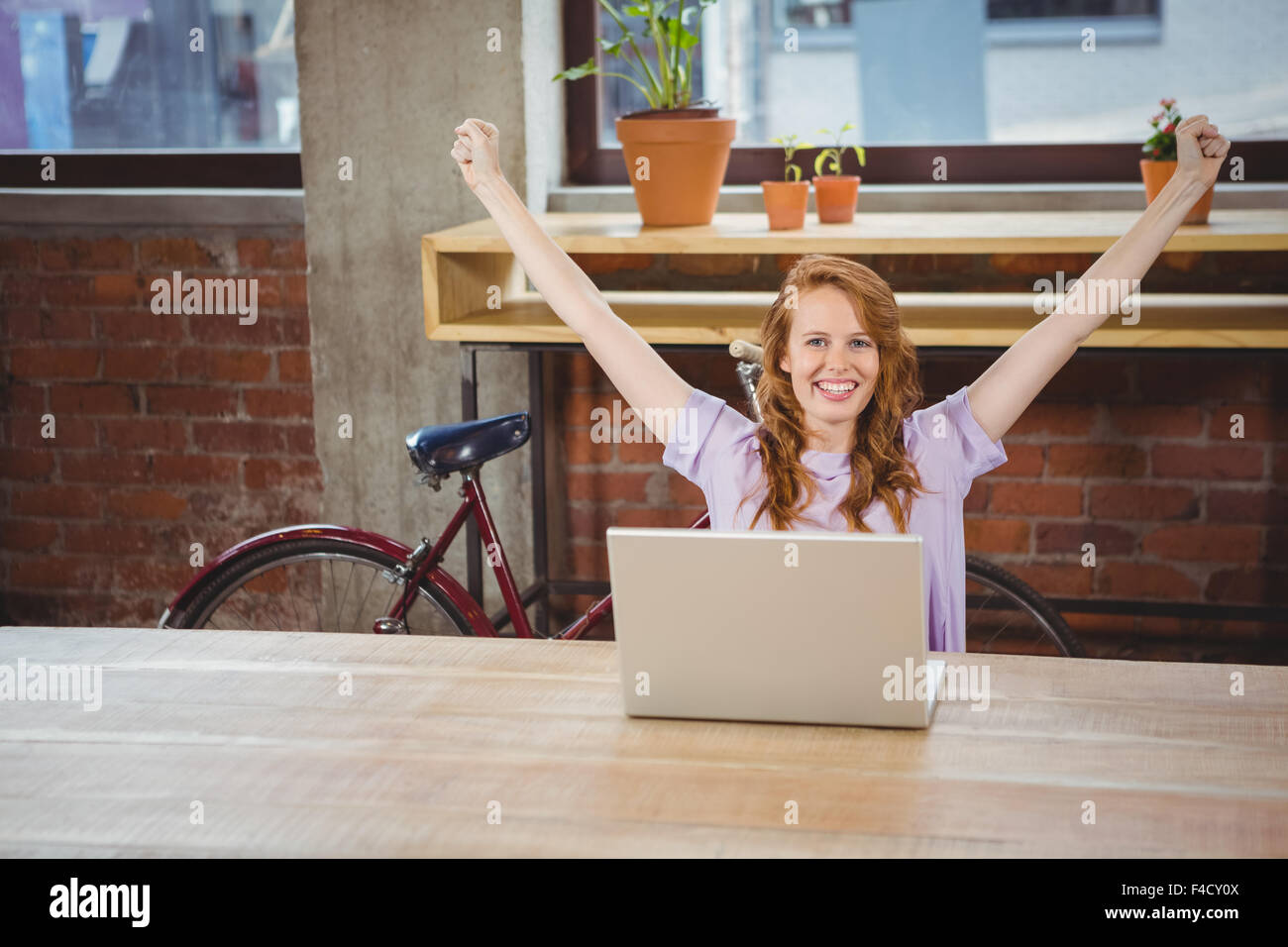 Happy woman with hands raised Stock Photo