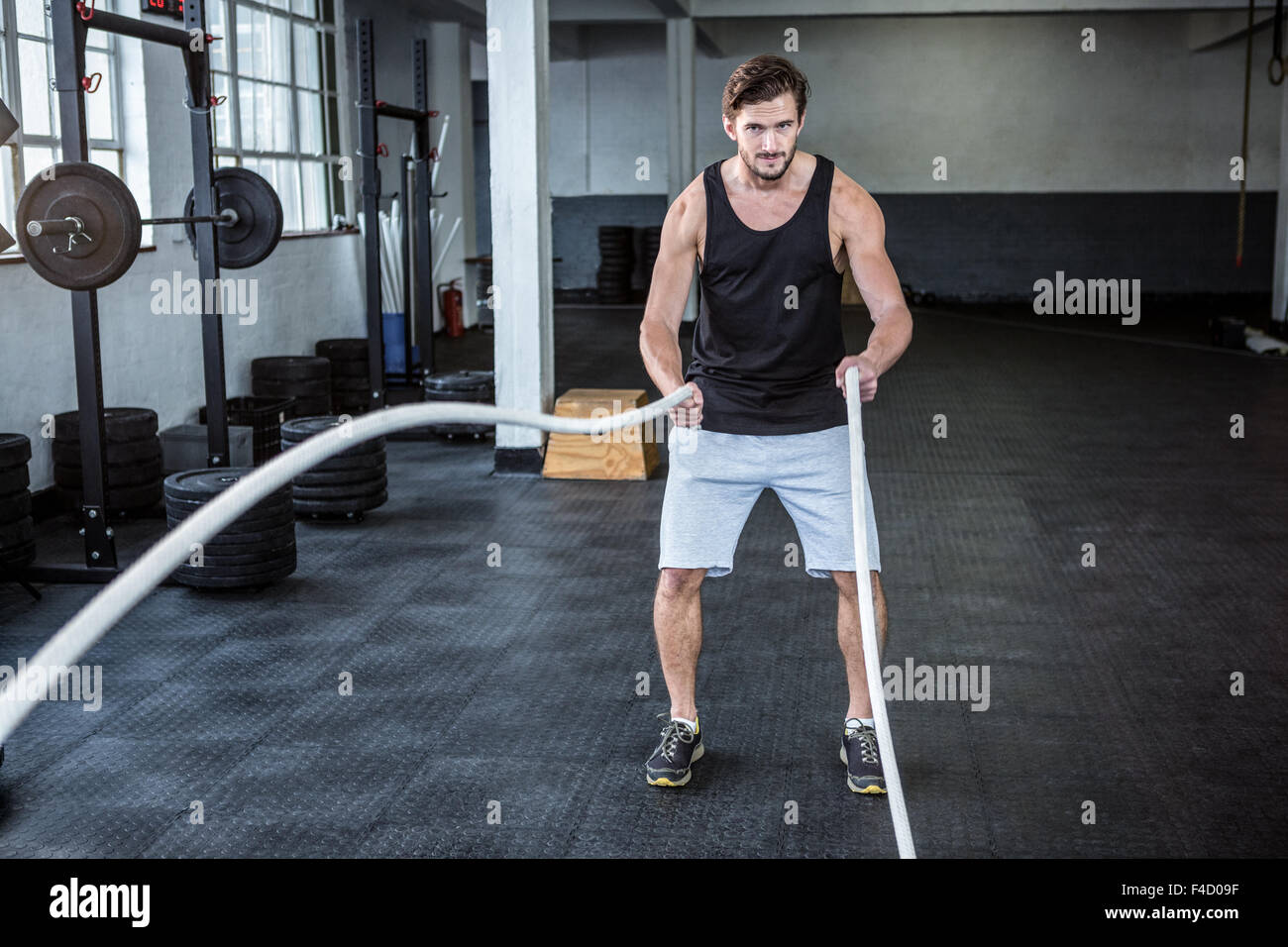 Fit man working out with battle ropes Stock Photo