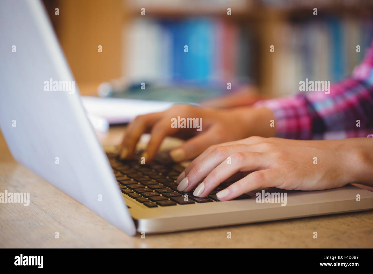 Cropped image of female student using laptop Stock Photo