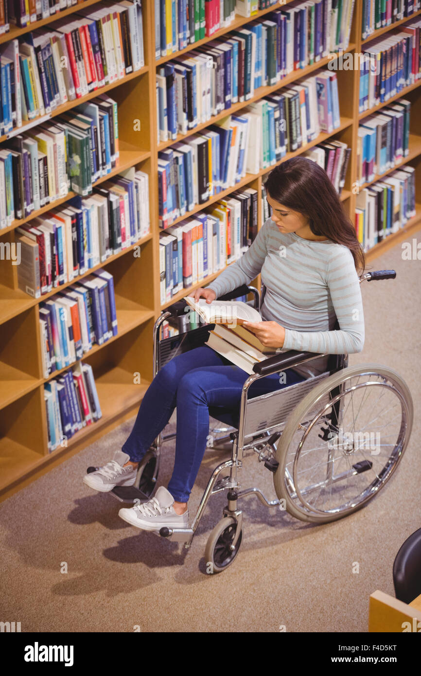 Disabled serious female student reading book Stock Photo
