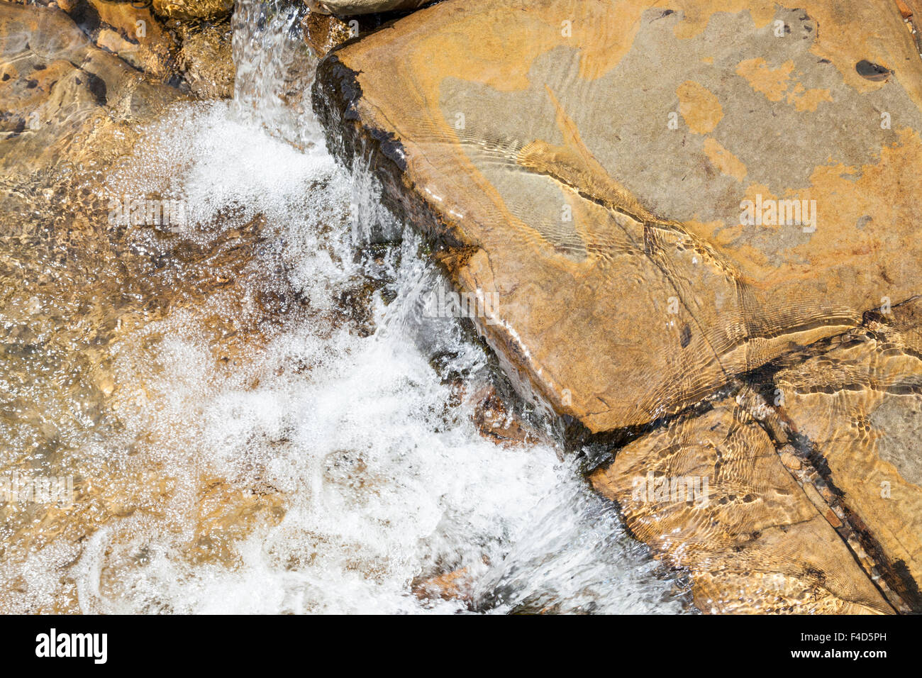 Close up of stream water flowing over rocks, England, UK Stock Photo