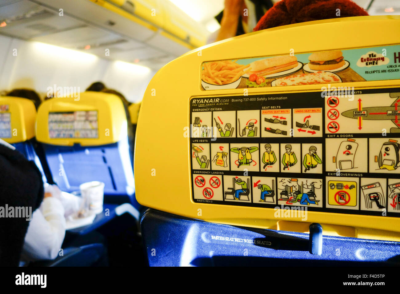 Ryanair cabin with advertising and safety cards on seatbacks Stock