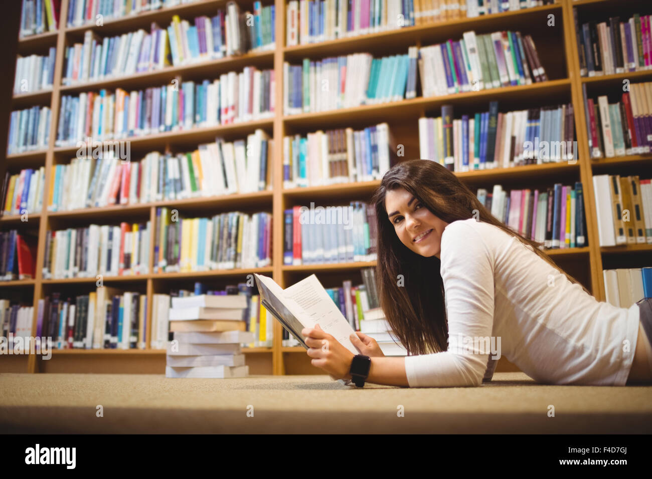 Portrait side view of happy female student lying with book Stock Photo ...