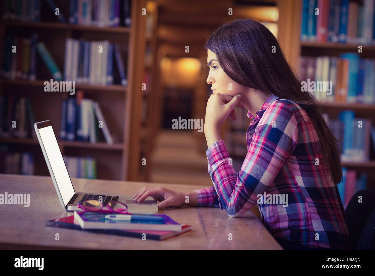 Concentrated female student working on laptop Stock Photo