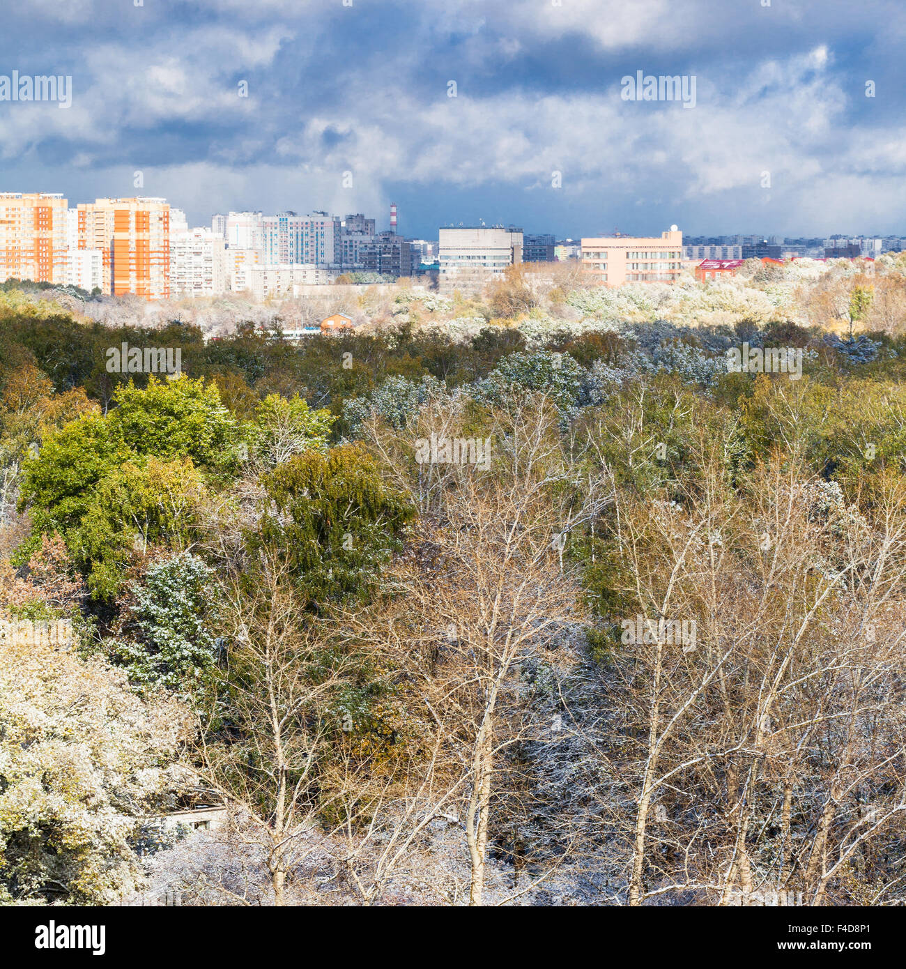 storm clouds over city and first snow on woods in autumn day Stock Photo