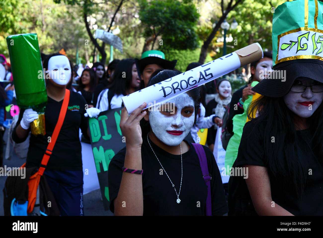 La Paz, Bolivia, 16th October 2015. A female student with her face painted white carries a giant cigarette with the words 'Say No to Drugs' on it during a march through La Paz city centre warning of the dangers of drug use. The demonstration is organised every year by the police together with schools and colleges to educate and raise awareness about drugs and their dangers. Credit: James Brunker / Alamy Live News Stock Photo