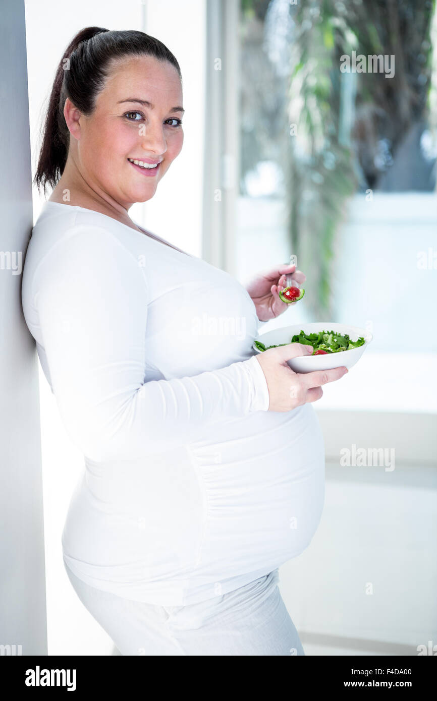 Pregnant smiling woman eating salad Stock Photo Alamy