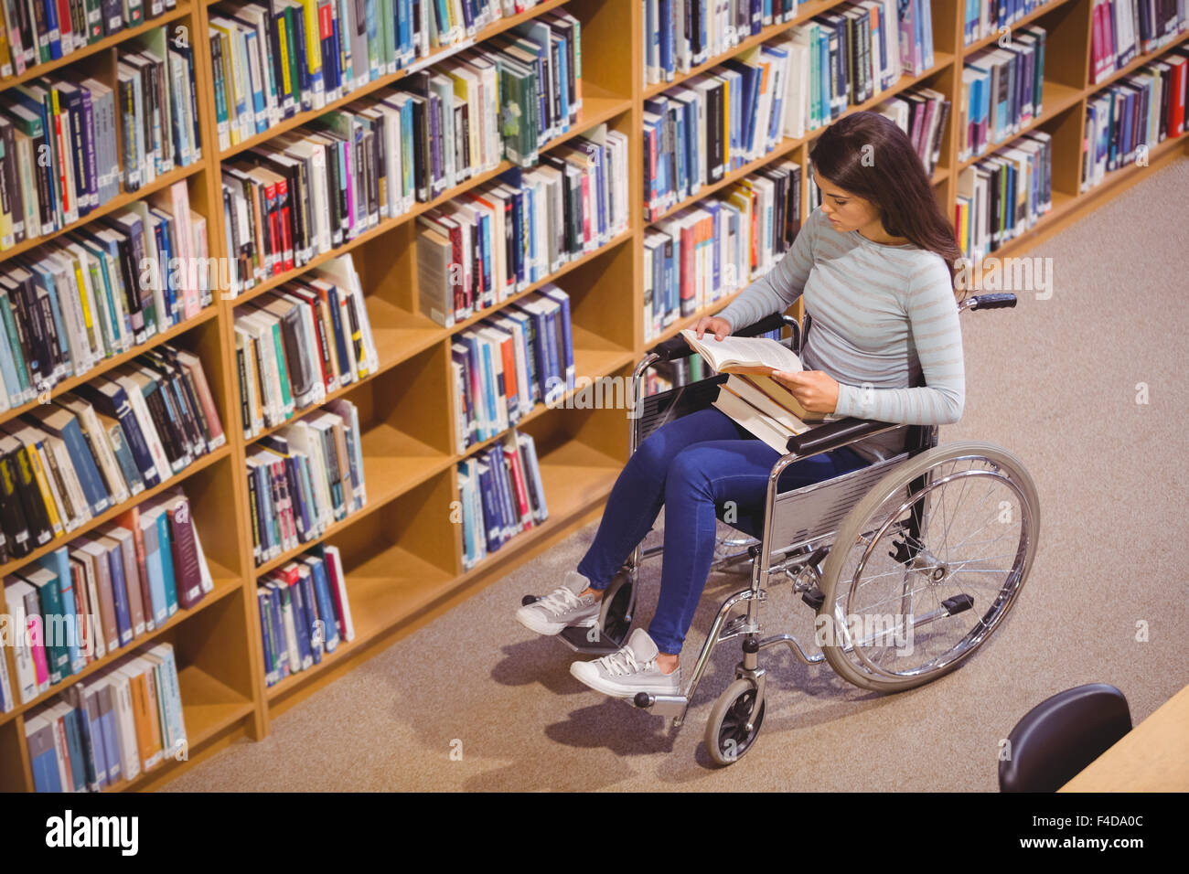 Disabled female student reading book Stock Photo