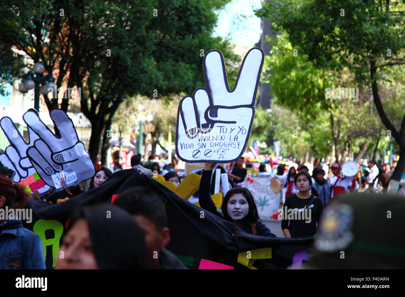 La Paz, Bolivia, 16th October 2015. A female student carries a large white hand making a V-sign for Victory with the slogan 'You and I living a life without drugs' during a march through La Paz city centre warning of the dangers of drug use. The demonstration is organised every year by the police together with schools and colleges to educate and raise awareness about drugs and their dangers. Credit: James Brunker / Alamy Live News Stock Photo