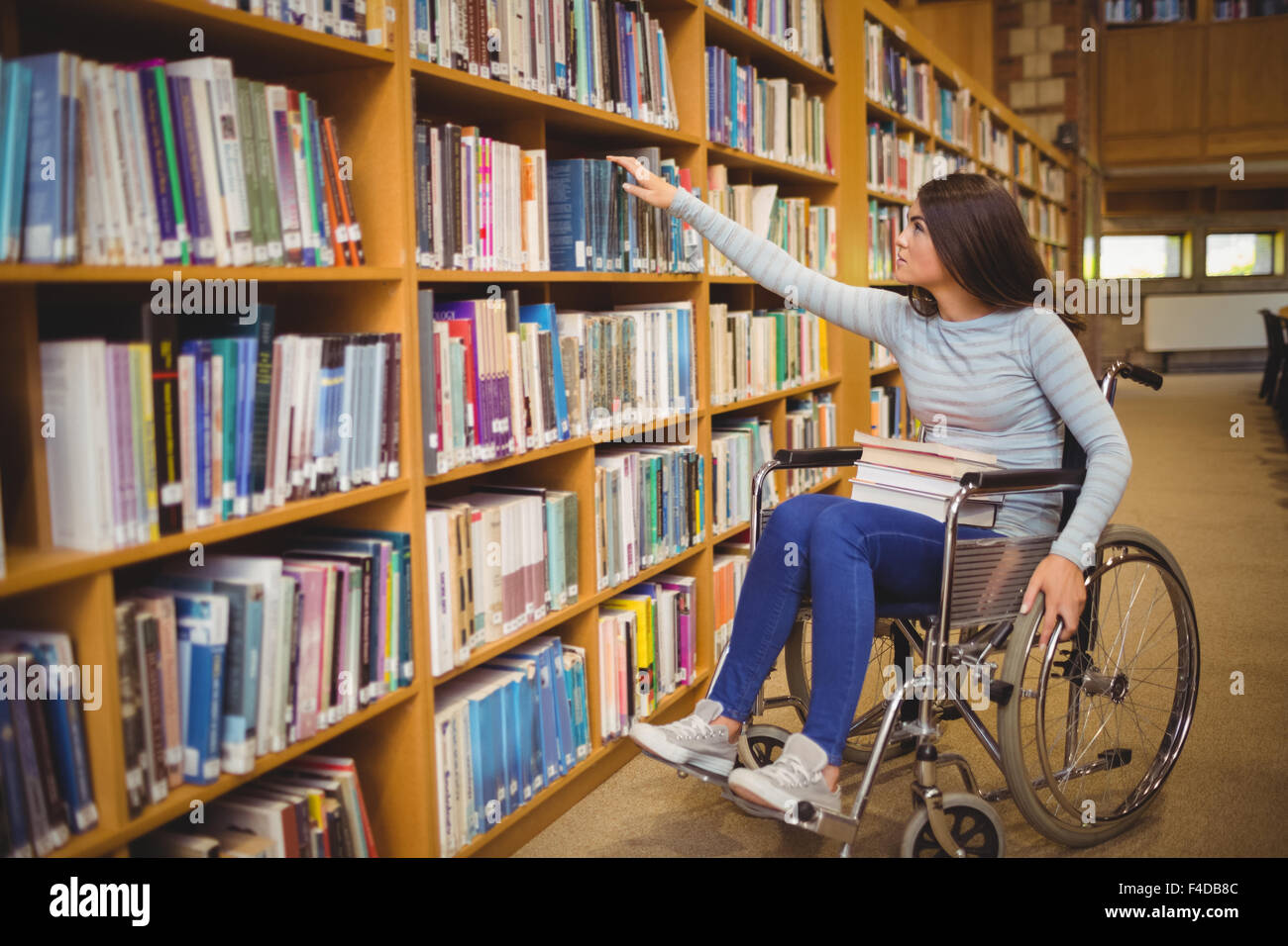 Disabled female student selecting book Stock Photo